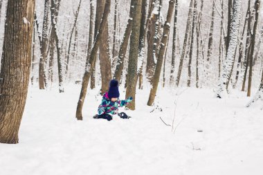 Kışın bir karda oynarken yürümeye başlayan çocuk.