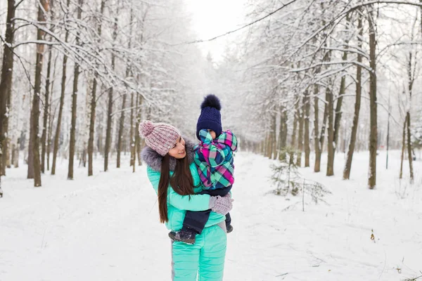 Mother and little toddler girl walking in the winter forest and having fun with snow. Family enjoying winter. Christmas and lifestyle concept. — Stock Photo, Image