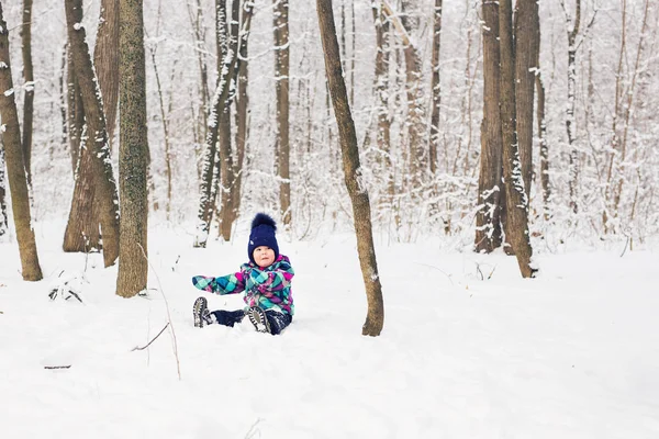 Niño pequeño jugando en una nieve en invierno . — Foto de Stock