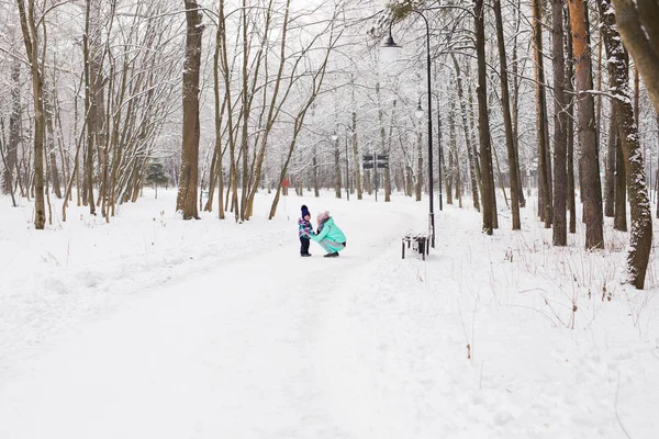 Mãe feliz e bebê no parque de inverno. família ao ar livre. mamãe alegre com seu filho — Fotografia de Stock