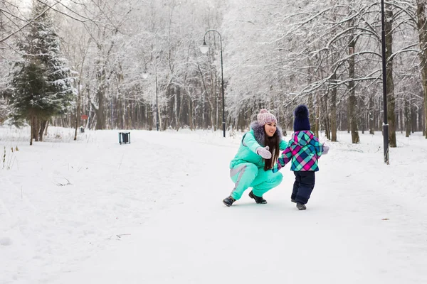 Família feliz mãe e bebê menina filha brincando e rindo no inverno ao ar livre na neve. — Fotografia de Stock