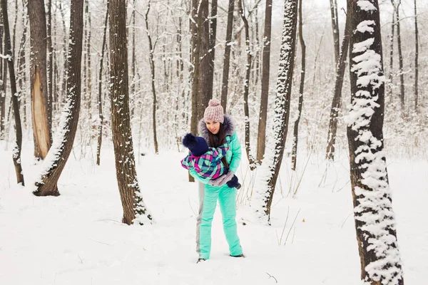 Mãe feliz e bebê no parque de inverno. família ao ar livre. mamãe alegre com seu filho — Fotografia de Stock