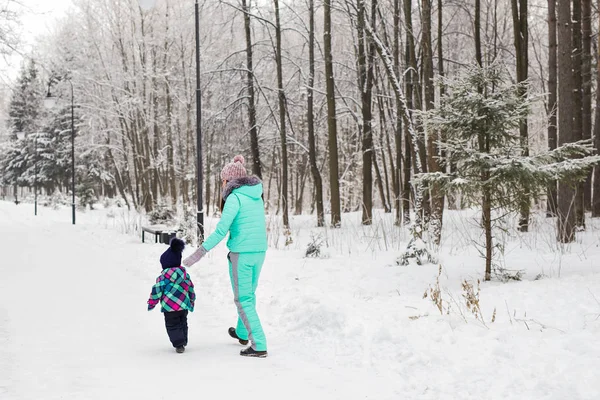 Mãe feliz e bebê no parque de inverno. família ao ar livre. mamãe alegre com seu filho — Fotografia de Stock