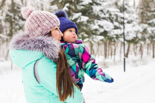 Happy mother and baby in winter park — Stock Photo, Image