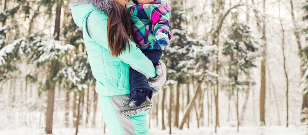 Gelukkig moeder en baby in winter park. familie buitenshuis. vrolijke mama met haar kind — Stockfoto