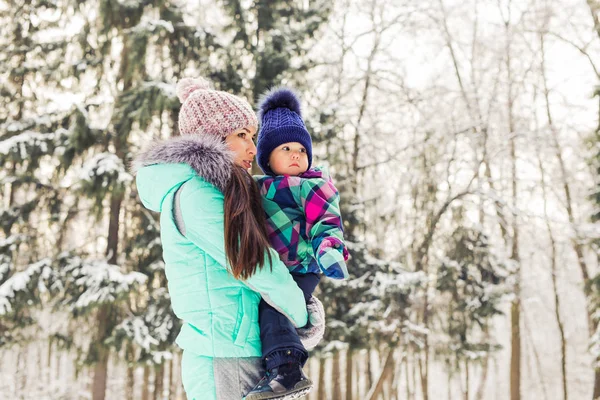 Happy family mother and baby girl daughter playing and laughing in winter outdoors in the snow. — Stock Photo, Image