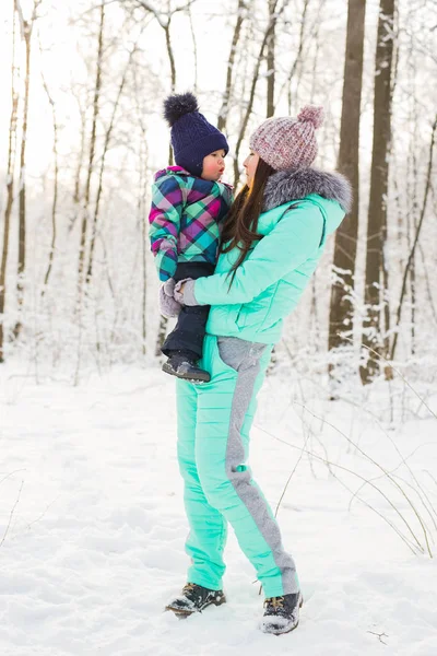 Happy mother and baby in winter park — Stock Photo, Image