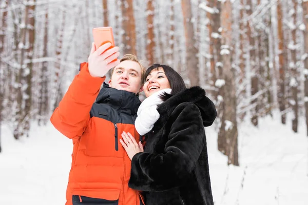 Couple heureux en hiver prendre des photos d'eux-mêmes avec smartphone — Photo