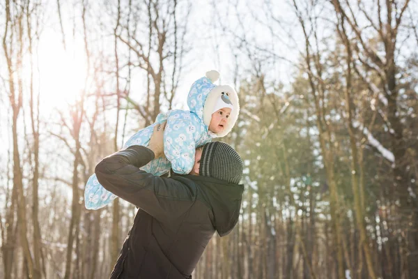 Família feliz em um passeio de inverno na natureza. Papai vomita bebê menino — Fotografia de Stock