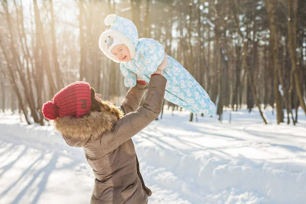 Happy mother and baby in winter park — Stock Photo, Image