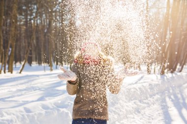 Kız parkta karla oynuyor