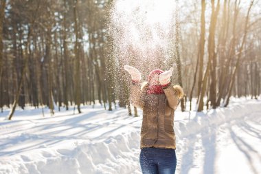 Kız parkta karla oynuyor