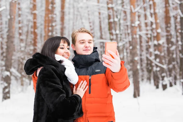 Para zakochanych, uśmiechając się i co selfie w zimie na zewnątrz — Zdjęcie stockowe