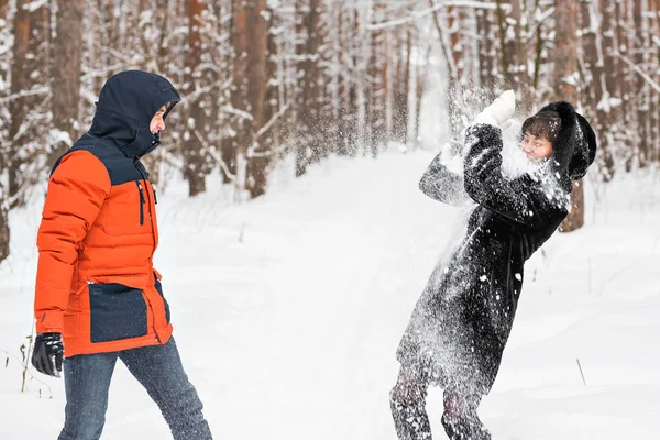 Pareja joven jugando en la nieve, teniendo pelea de bolas de nieve — Foto de Stock