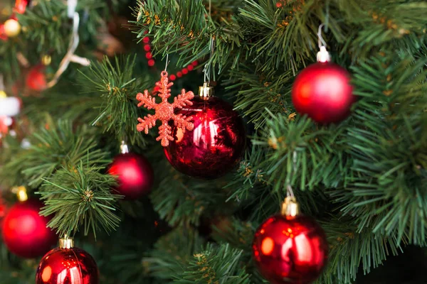 Close-up van rode kerstballen opknoping van een versierde kerstboom. — Stockfoto