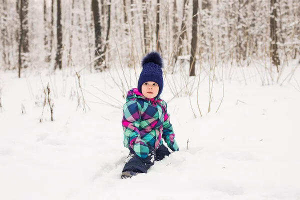 Смеющаяся девочка, лежащая в снегу — стоковое фото