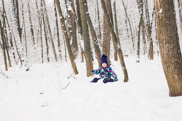 Niña riendo acostada en la nieve — Foto de Stock
