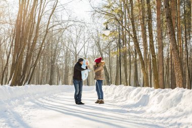 Ebeveynlik, moda, sezon ve insanlar kavramı - çocuk açık havada yürüyüş kış giysileri ile mutlu aile.