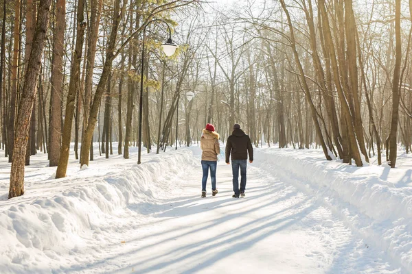 Concept de parentalité, de mode, de saison et de personnes - famille heureuse avec enfant en vêtements d'hiver marchant à l'extérieur . — Photo