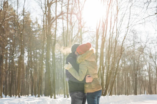 Jovem casal abraçando e beijando no parque no inverno . — Fotografia de Stock