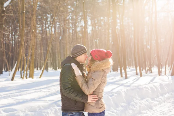 Jovem casal abraçando e beijando no parque no inverno . — Fotografia de Stock