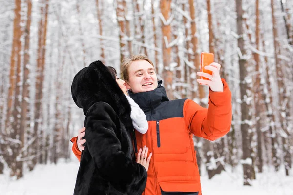 Para zakochanych, uśmiechając się i co selfie w zimie na zewnątrz — Zdjęcie stockowe