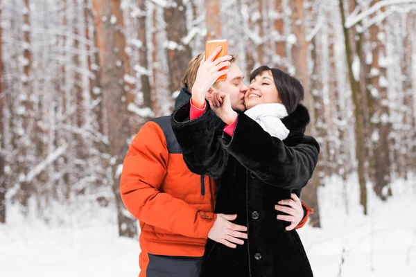 Para zakochanych, uśmiechając się i co selfie w zimie na zewnątrz — Zdjęcie stockowe