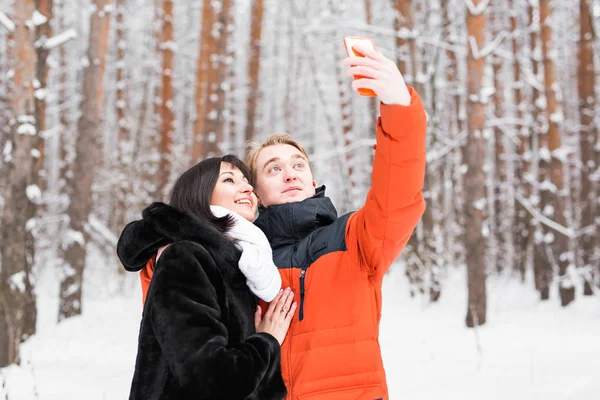 Para zakochanych, uśmiechając się i co selfie w zimie na zewnątrz — Zdjęcie stockowe