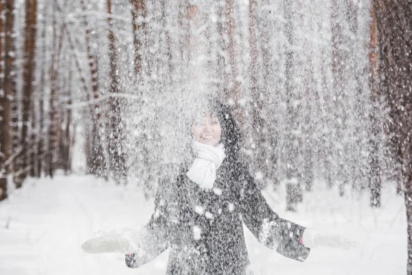 女の子は公園で雪と遊ぶ — ストック写真