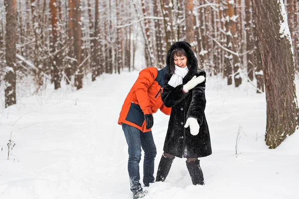 若いカップルの雪合戦を持っている雪の中で遊ぶこと — ストック写真