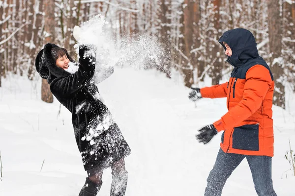 Jeune couple jouant dans la neige, ayant combat de boule de neige — Photo