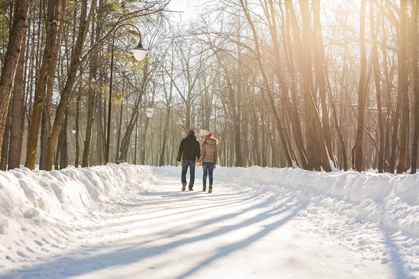 Jeune couple amoureux marchant dans la forêt enneigée — Photo