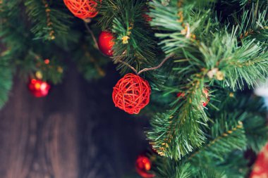 Kırmızı baubles dekore edilmiş bir Noel ağaca tutunan closeup.