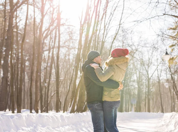Jeune couple embrassant et embrassant dans le parc en hiver . — Photo