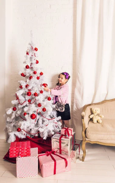 8 anos de idade menina decorando árvore de Natal em casa . — Fotografia de Stock