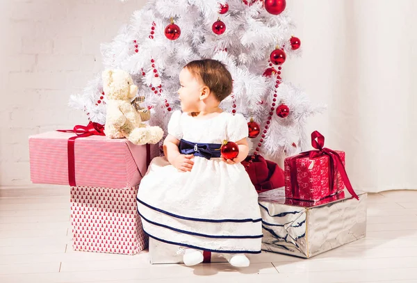 Happy baby barn flicka nära en julgran — Stockfoto
