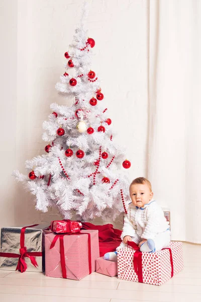 Χαρούμενος λίγο μωρό αγόρι παίζει κοντά στο χριστουγεννιάτικο δέντρο — Φωτογραφία Αρχείου