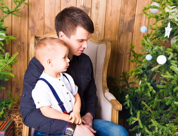 Familie, vakantie en Kerstmis concept - vader en zoon in de buurt van de kerstboom — Stockfoto