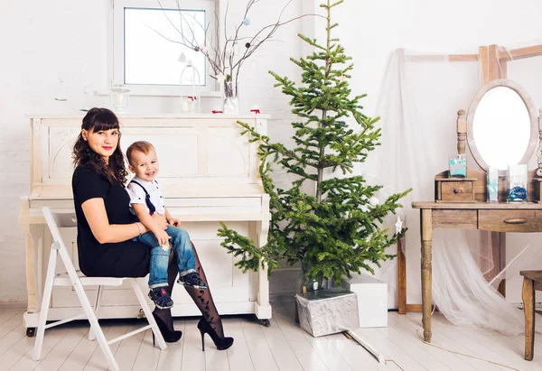 Familie, vakantie en Kerstmis concept - moeder en zoon in de buurt van de kerstboom — Stockfoto