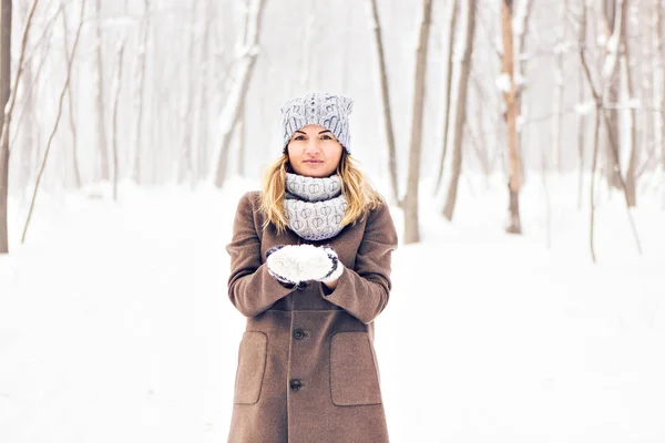 Красивая зимняя женщина играет со снегом — стоковое фото