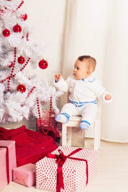 Noel ağacının yakınında evde küçük bir çocuk portresi.