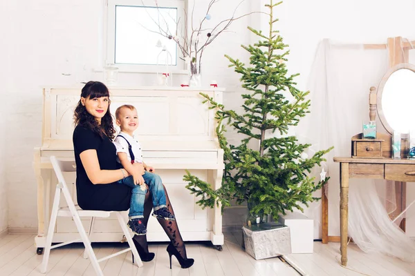 Moeder met haar zoon viert vakantie in de buurt van de kerstboom — Stockfoto