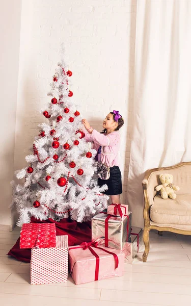 8 anos de idade menina decorando árvore de Natal em casa . — Fotografia de Stock