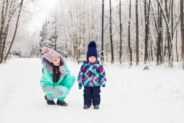 Happy mother and baby in winter park. family outdoors. cheerful mommy with her child — Stock Photo, Image