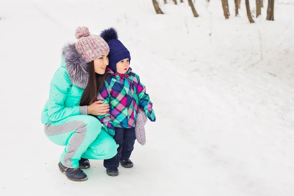 Happy mother and baby in winter park — Stock Photo, Image