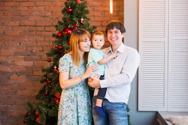 Feliz familia sonriente cerca del árbol de Navidad —  Fotos de Stock