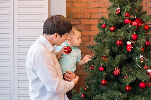 Padre e hijo están decorando el árbol de Navidad — Foto de Stock