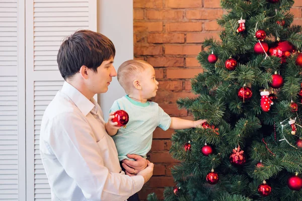 Padre e hijo están decorando el árbol de Navidad — Foto de Stock
