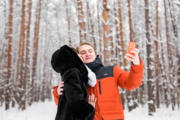 Atrakcyjna para robi selfie na zewnątrz. — Zdjęcie stockowe