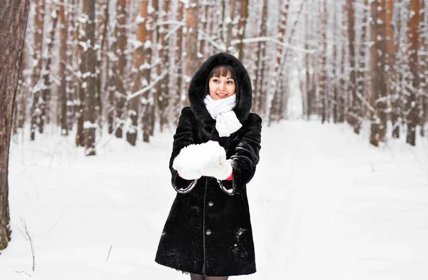 Young woman in fur coat outdoors in snow garden — Stock Photo, Image